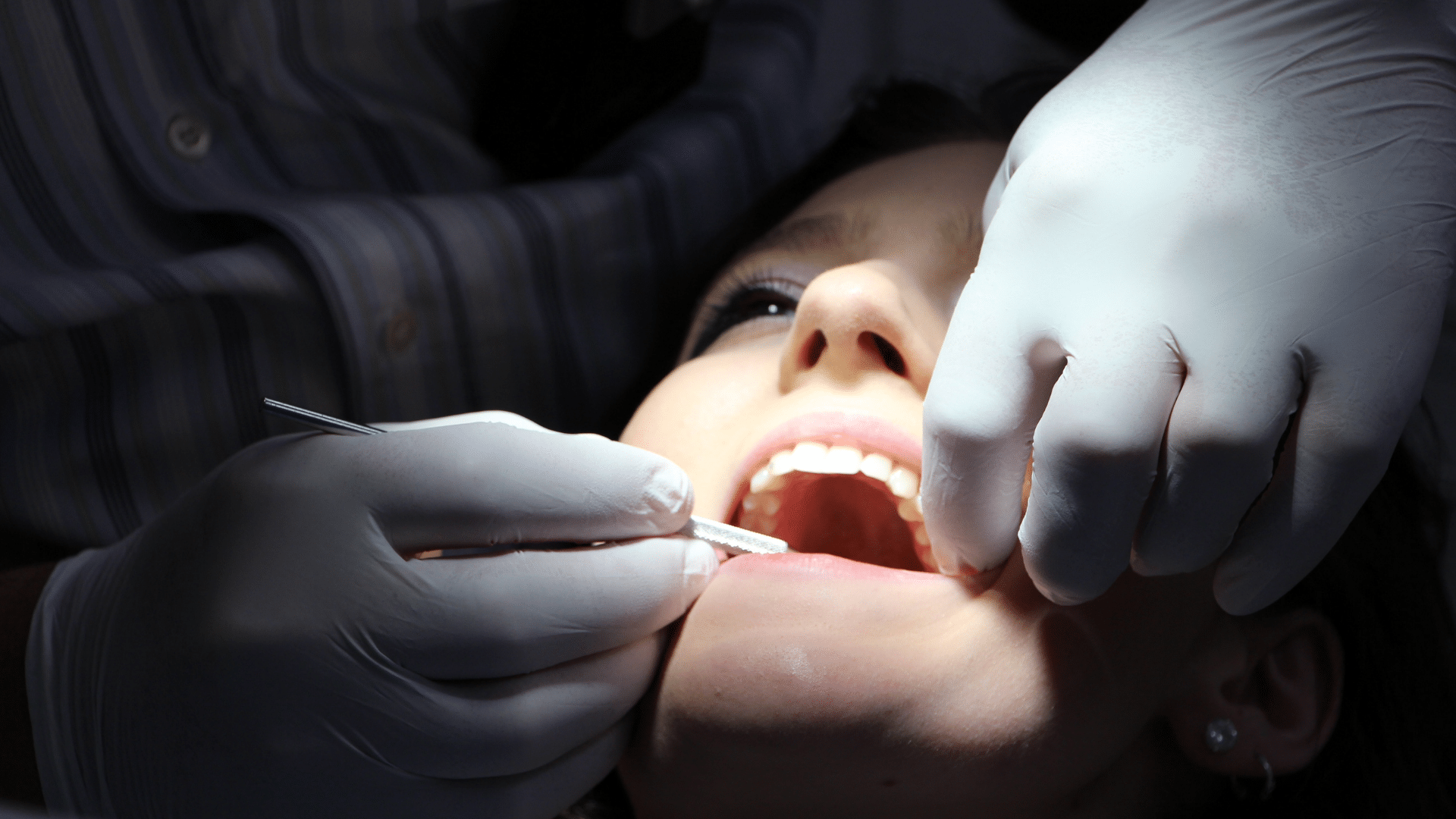 An image of a professional services specialist working on a client in a dentist office.
