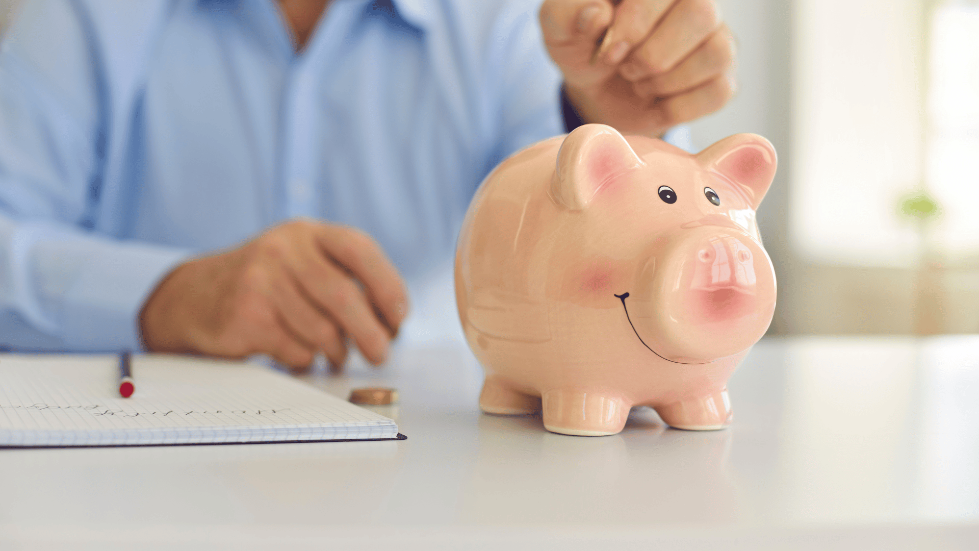 An image of someone saving money in a piggy bank